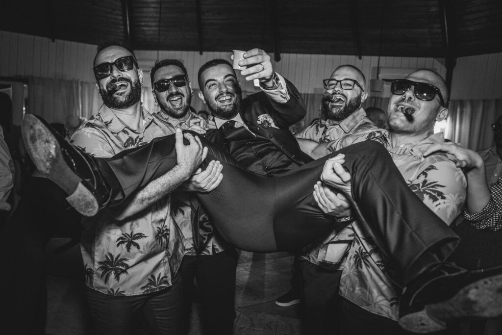 Lo sposo sollevato dagli amici durante la festa di matrimonio